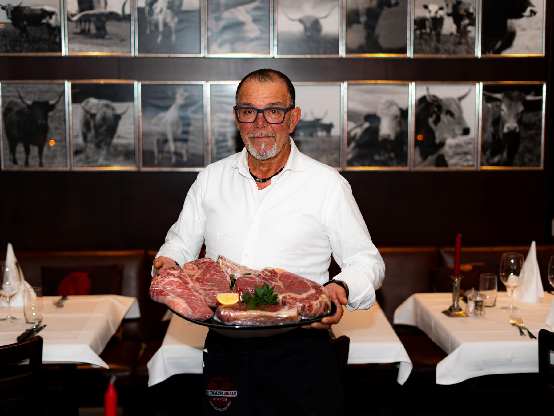 Gastgeber von The Black Bulls präsentiert eine Platte mit Steaks
